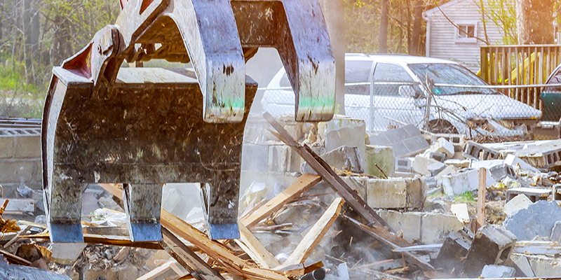 Demolition-Service-Feature A claw is removing debris and junk from a job site.