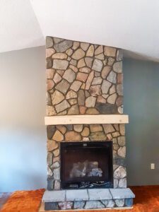 A stone fireplace going into an angled ceiling.