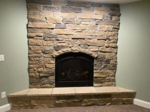 A brick fireplace built in a corner of a room.