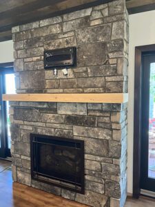 A mantle is being added to a brick fireplace.
