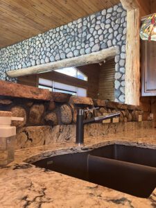 A stone arch in the background of a kitchen with decorative stone counter.