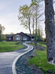 A very long windy cement walking path leading to a house.