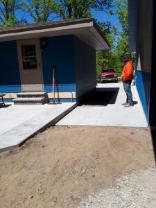 A cement patio and walkway have been built around a home.