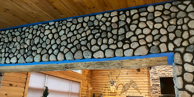 Custom-Masonry-Projects-Feature Custom river rock stone fireplace surround and rustic timber mantel by Trepanier Masonry in Bemidji, MN.