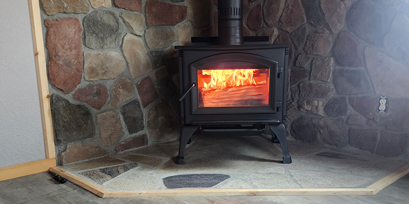 Masonry-Indoor-Fireplace-Feature-1 Wood-burning stove installed on a custom natural stone fireplace hearth by Trepanier Masonry in Bemidji, MN.